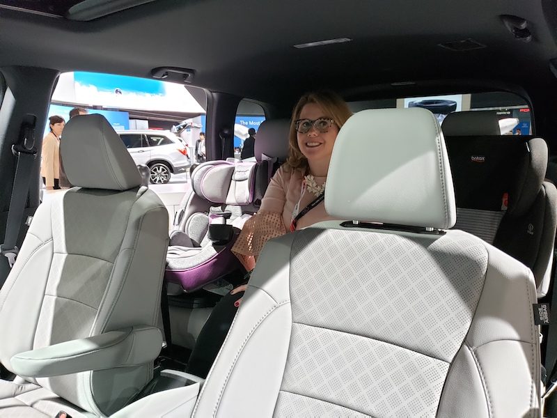 Which 2 Row SUVs Are Best For Child Car Seats? The Ultimate Car Seat Challenge 6 Woman Sitting In Honda'S Backseat In-Between Two Car Seats