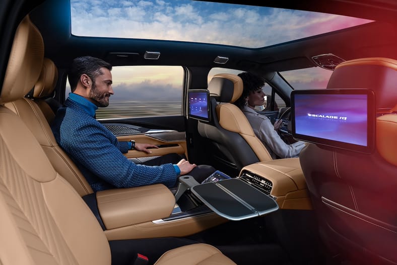 Why We're So Excited to Drive the Cadillac Escalade IQ... It'll Be Worth the Wait 12 Man Sitting In Executive Second Row Of Cadillac Escalade Iq With Backseat Screens.